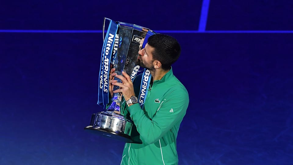 Novak Djokovic kisses the Nitto ATP Finals trophy after victory against Jannik Sinner