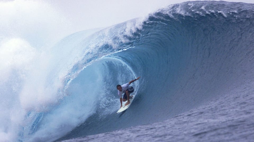 A male surfer navigates a barrel at Teahupo'o.