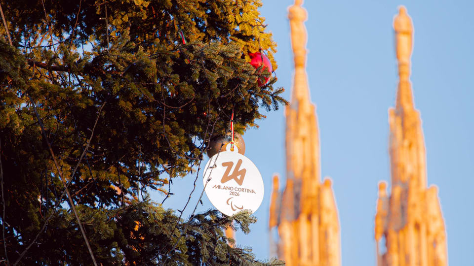 Foto di dettaglio della medaglia di Milano Cortina 2026 appesa ad un ramo dell'albero di natale posizionato in piazza Duomo 
