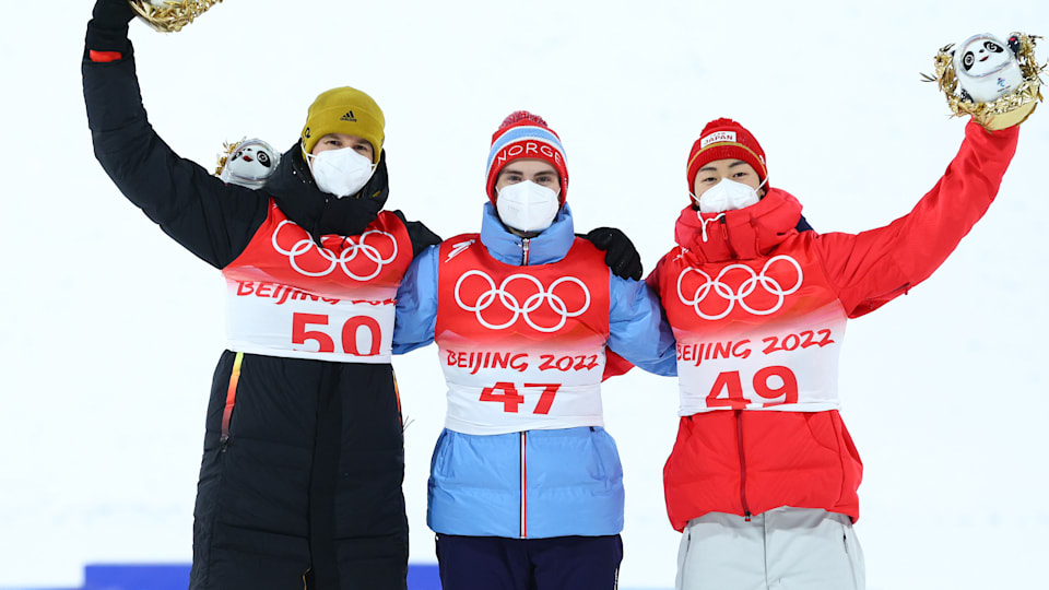 Gold medal winner Marius Lindvik of Team Norway (C), Silver medal winner Ryoyu Kobayashi of Team Japan (R) and Bronze medal winner Karl Geiger of Team Germany (L) celebrate during the flower ceremony following the Men's Large Hill Individual Final Round on Day 8 of Beijing 2022 Winter Olympic Games