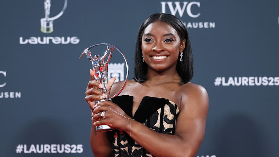 Simone Biles poses with the award during the 2025 Laureus World Sport Awards winners walk