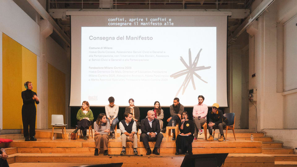 Foto di persone protagoniste dell'evento sedute sul palco del BASE