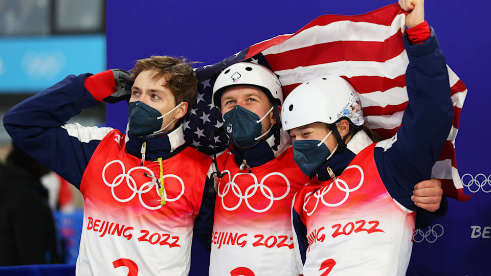 Christopher Lillis, Justin Schoenefeld and Ashley Caldwell of Team United States react after winning the gold medal during the Freestyle Skiing Mixed Team Aerials on Day 6 of the Beijing 2022 Winter Olympic Games