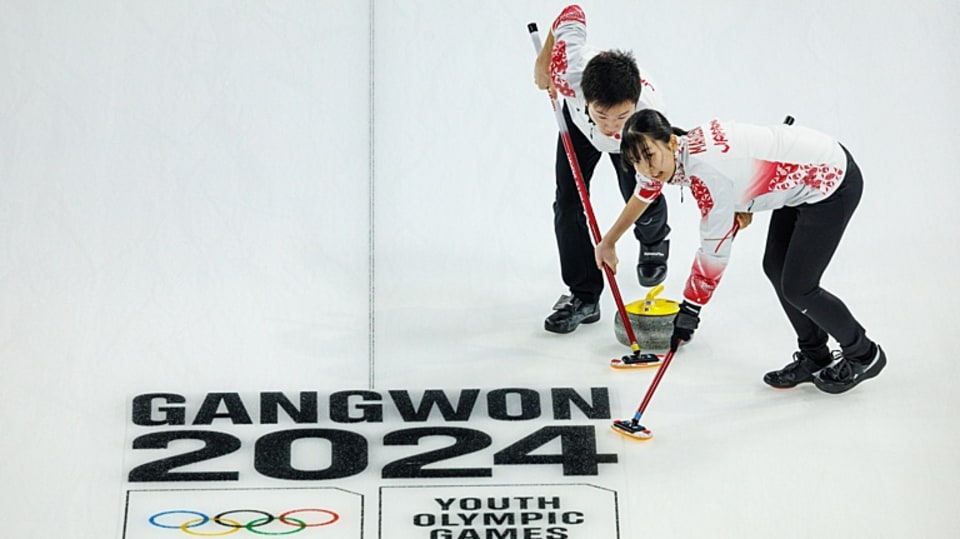 Maruzeni Satsuki JPN and Sato Koei JPN sweeping the ice in the first round of the Curling Mixed Team Round Robin match between Japan and United States of America at the Gangneung Curling Centre