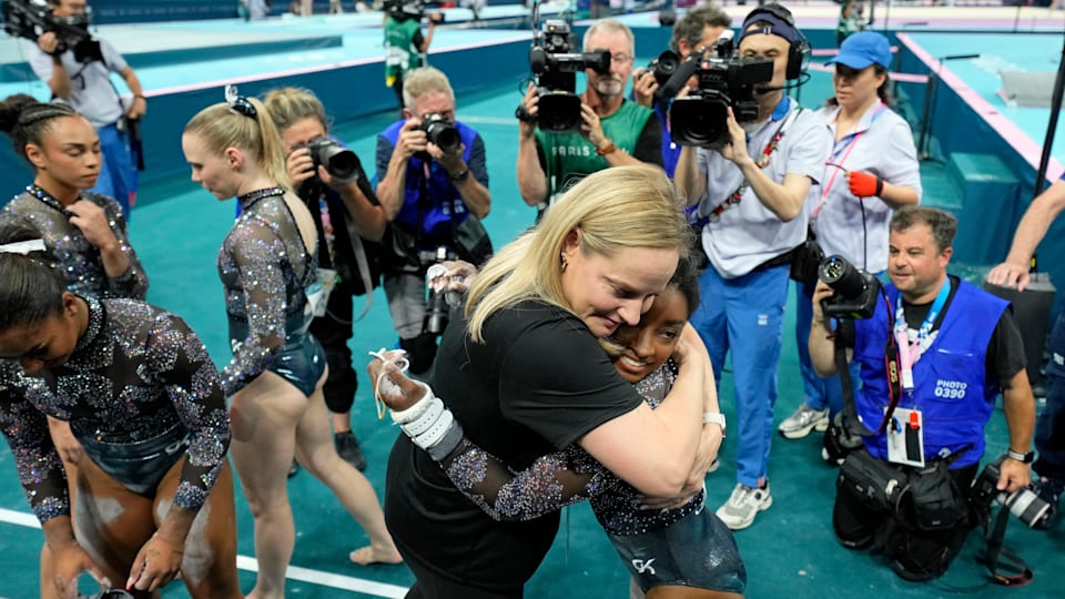 Simone Biles of the United States hugs coach Cecile Landi after women’s qualification