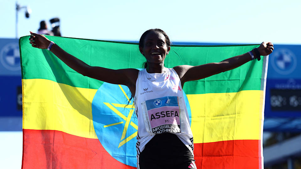 Tigst Assefa holds the Ethiopian flag after her world record at the 2023 Berlin Marathon