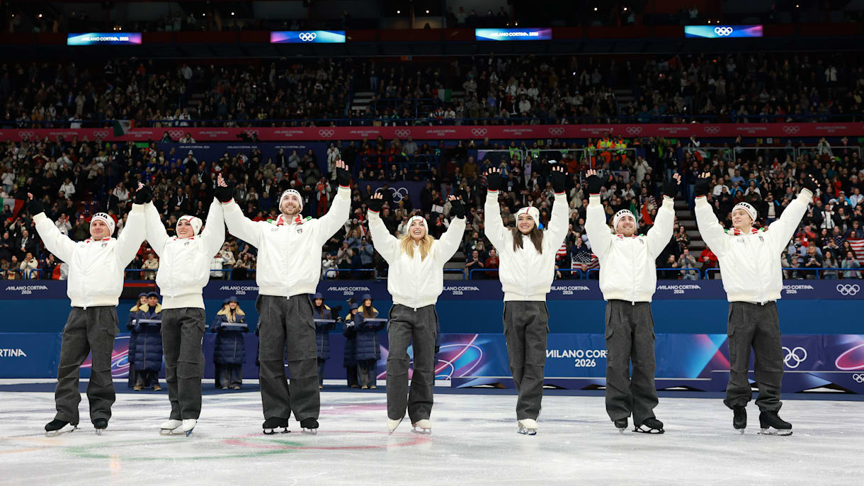 Figure skaters performing inside a packed Olympic arena