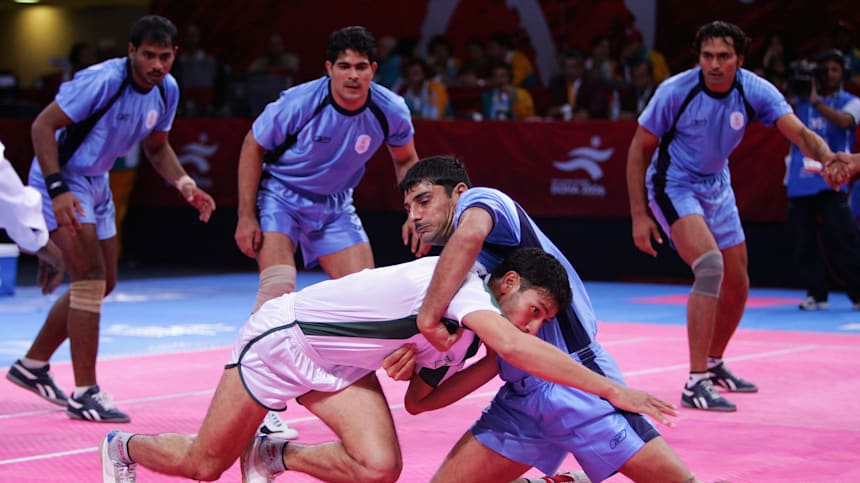 A defender trying to stop a raider from reaching their own half during a kabaddi match