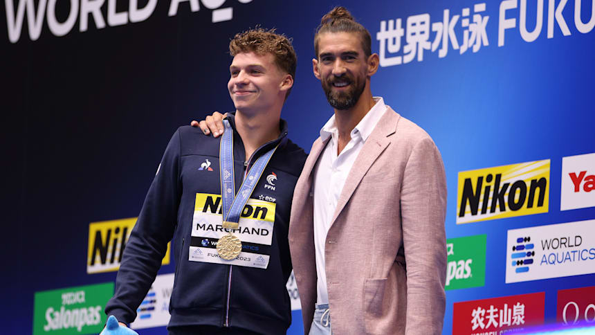 León Marchand (izq.) con Michael Phelps después de ganar los 400m estilos individual en Fukuoka 2023