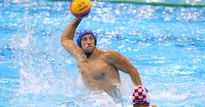 ватерполисты в прыжке за мячом над водой